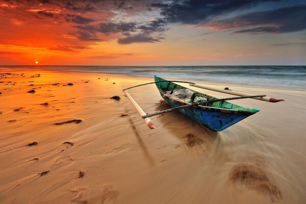 Bateau solitaire sur la plage de sable dans la soirée