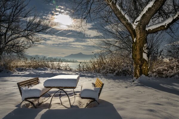 Table and benches on a background of white snow