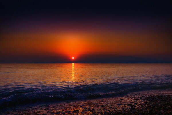 Bord de mer avec vue sur le coucher de soleil rouge