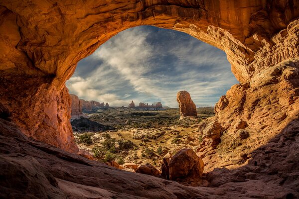 Cave in the form of an arch with a view of the canyon