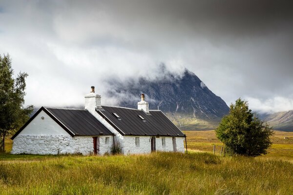 Scottish cottage on the background of clouds