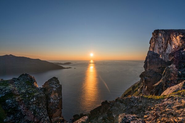 Puesta de sol en el fondo de las montañas y el mar