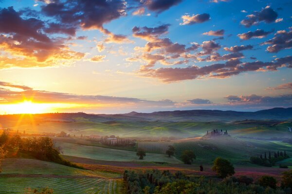 Fog over the valley with the village at sunset