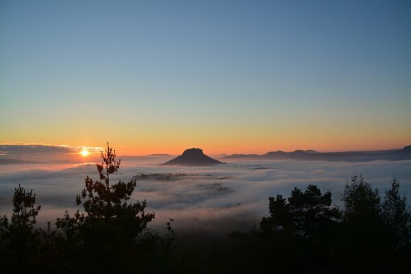 Mountain in the fog, sunset sky