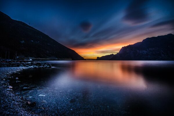 Montañas lago y puesta de sol en el cielo