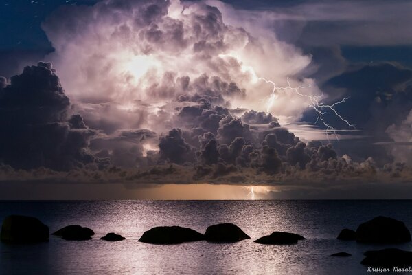 Nuage de nuit avec la foudre au-dessus de la mer