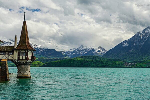 Wieża Oberhofen na tle gór i jeziora w Szwajcarii