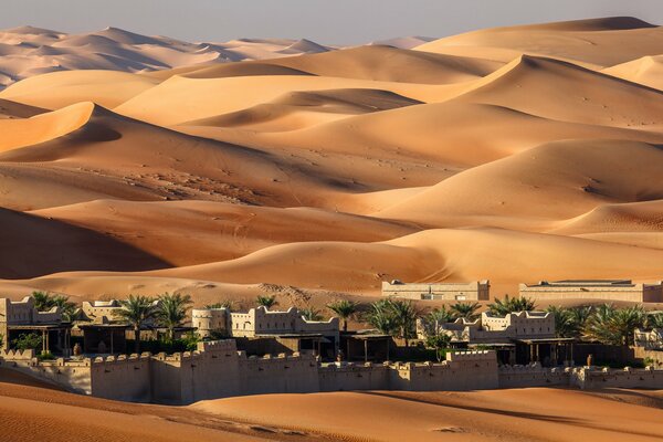 Maisons dans le désert sur fond de barkhan