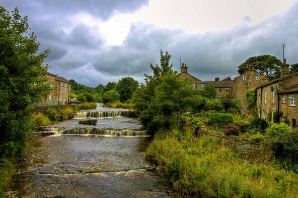 Villaggio inglese vicino al fiume in una giornata nuvolosa