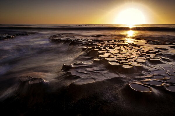 Der atemberaubende Strand spiegelt den Sonnenuntergang wider