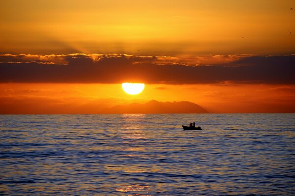 Zwei in einem Boot im Meer bei Sonnenuntergang