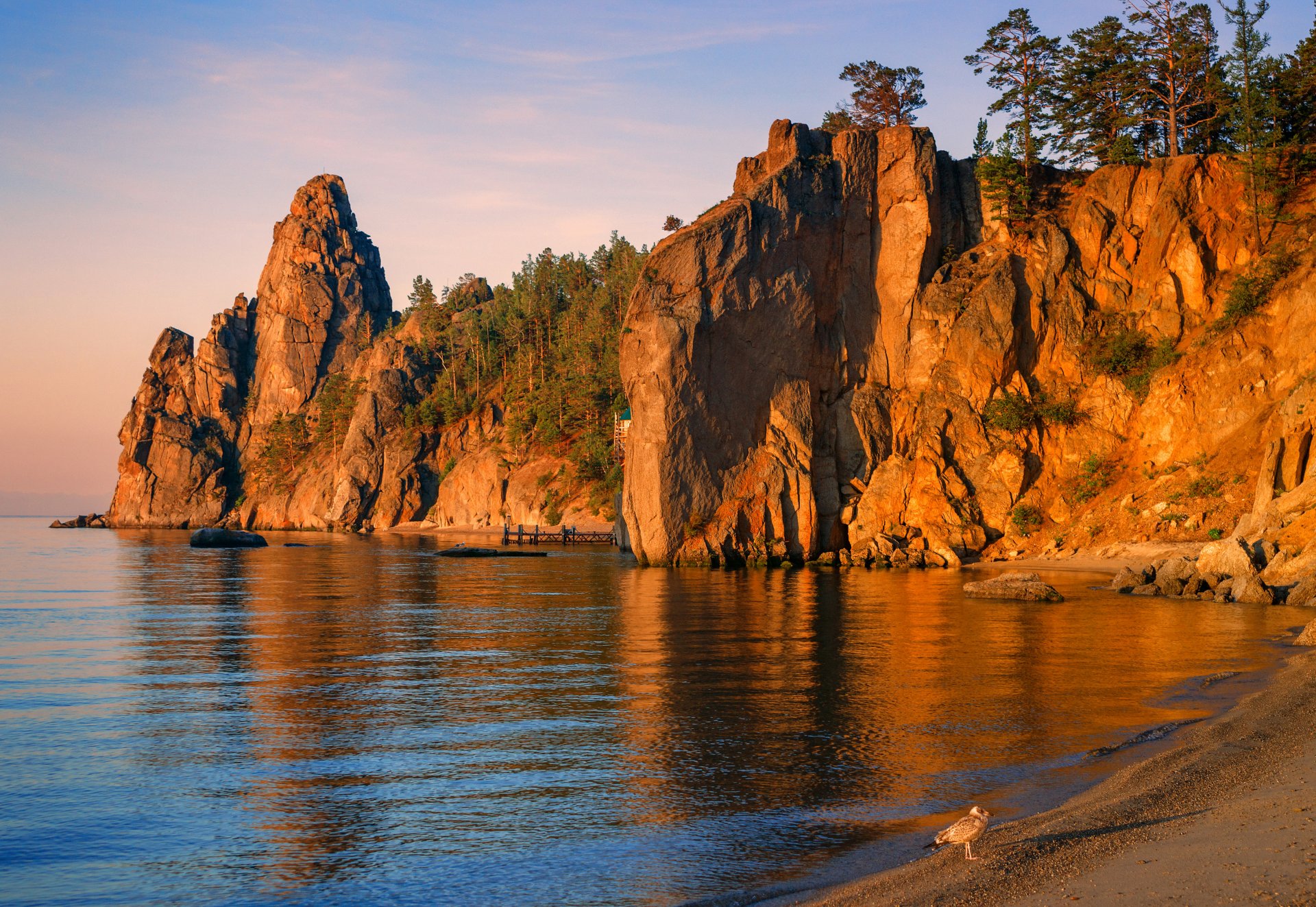 rusia lago baikal rocas árboles costa muelle pájaro puesta de sol