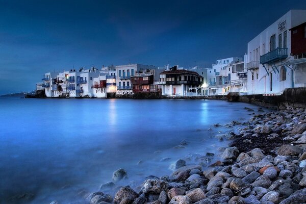 Les maisons grecques jouets brillent d une lueur de lune sur le rivage rocheux de la mer