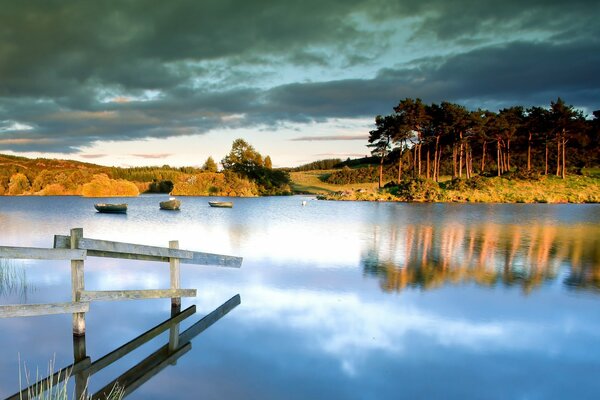 A bridge on the lake and pine trees in the distance