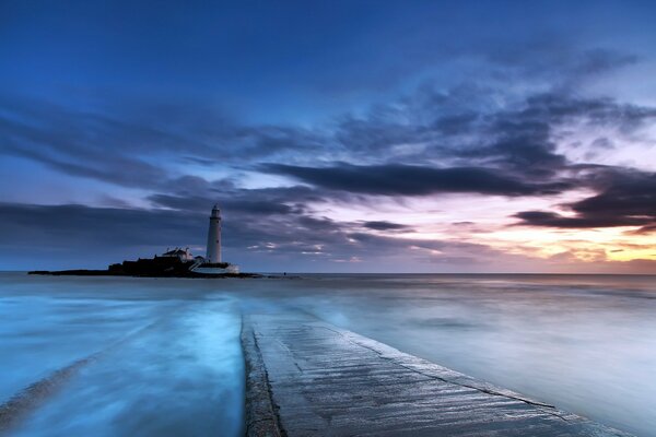 Sunset on the sea and the lighthouse in the distance