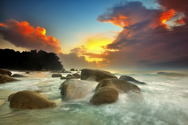 Sunset on the background of the sea and rocks
