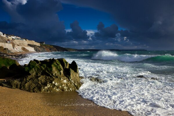 Clouds are gathering over the sea beating against the rocks