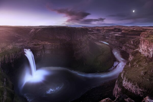 Waterfall in the canyon under the lilac sky