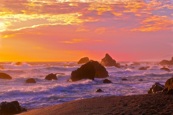 Strand mit Felsen bei Sonnenuntergang