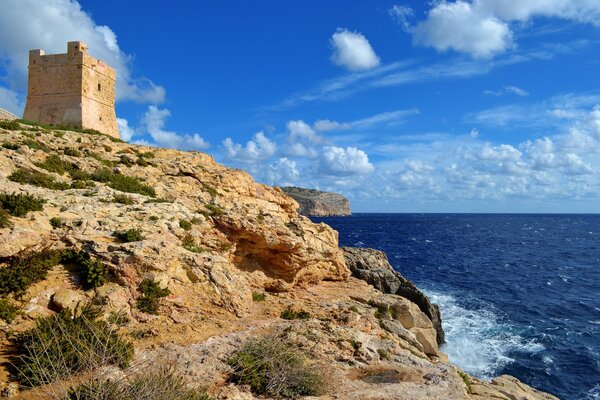 Una fortaleza solitaria se encuentra en la orilla de arcilla sobre el mar azul profundo