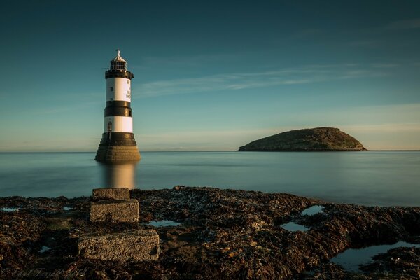 Lighthouse on the sea with a view of the island