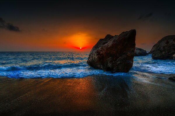 Grandi pietre sullo sfondo del tramonto del mare