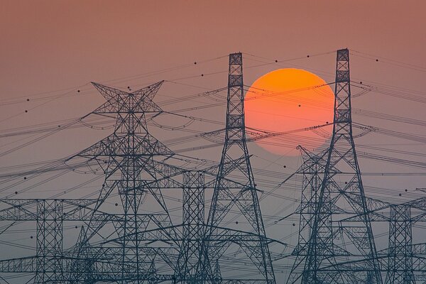 Líneas de transmisión en el fondo de una puesta de sol roja brillante