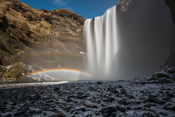 Cascade et arc-en-ciel sur fond de ciel bleu