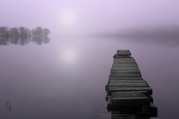 Brücke an einem Nebel gehüllten See