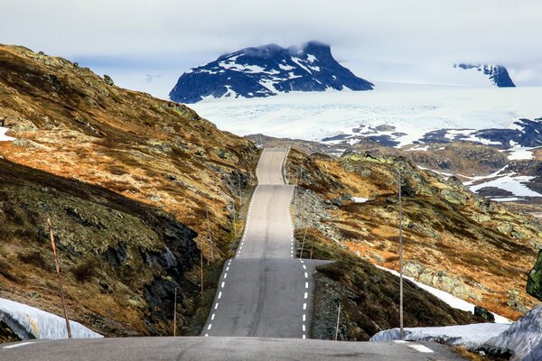 Узкая горная дорога среди норвежских снегов