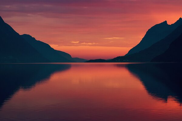 Sunset on the sea and mountains in a burgundy haze