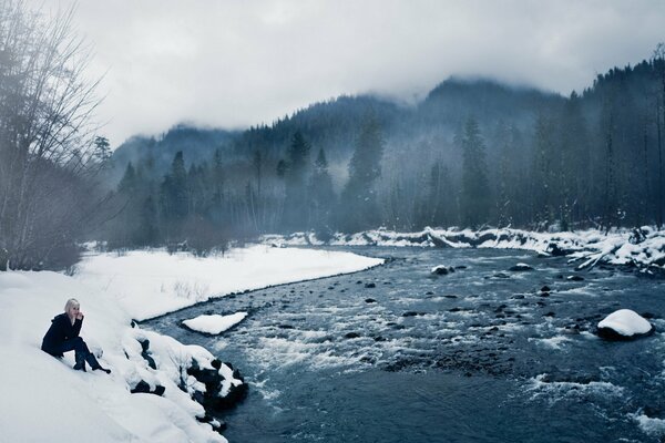 Mädchen am Ufer eines eisigen Wintersees