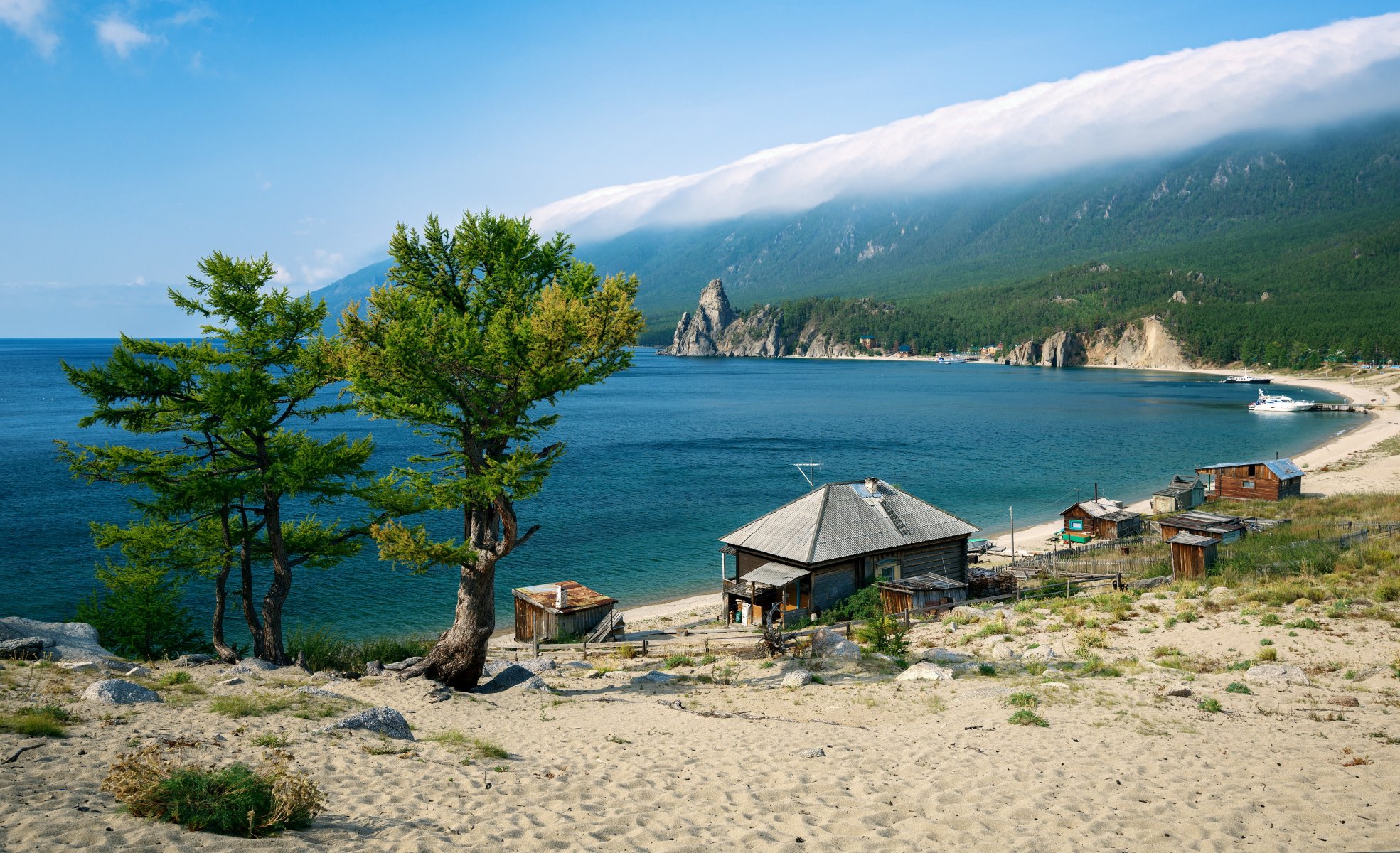 russia lago baikal costa sabbia casa alberi montagne nuvole cielo blu