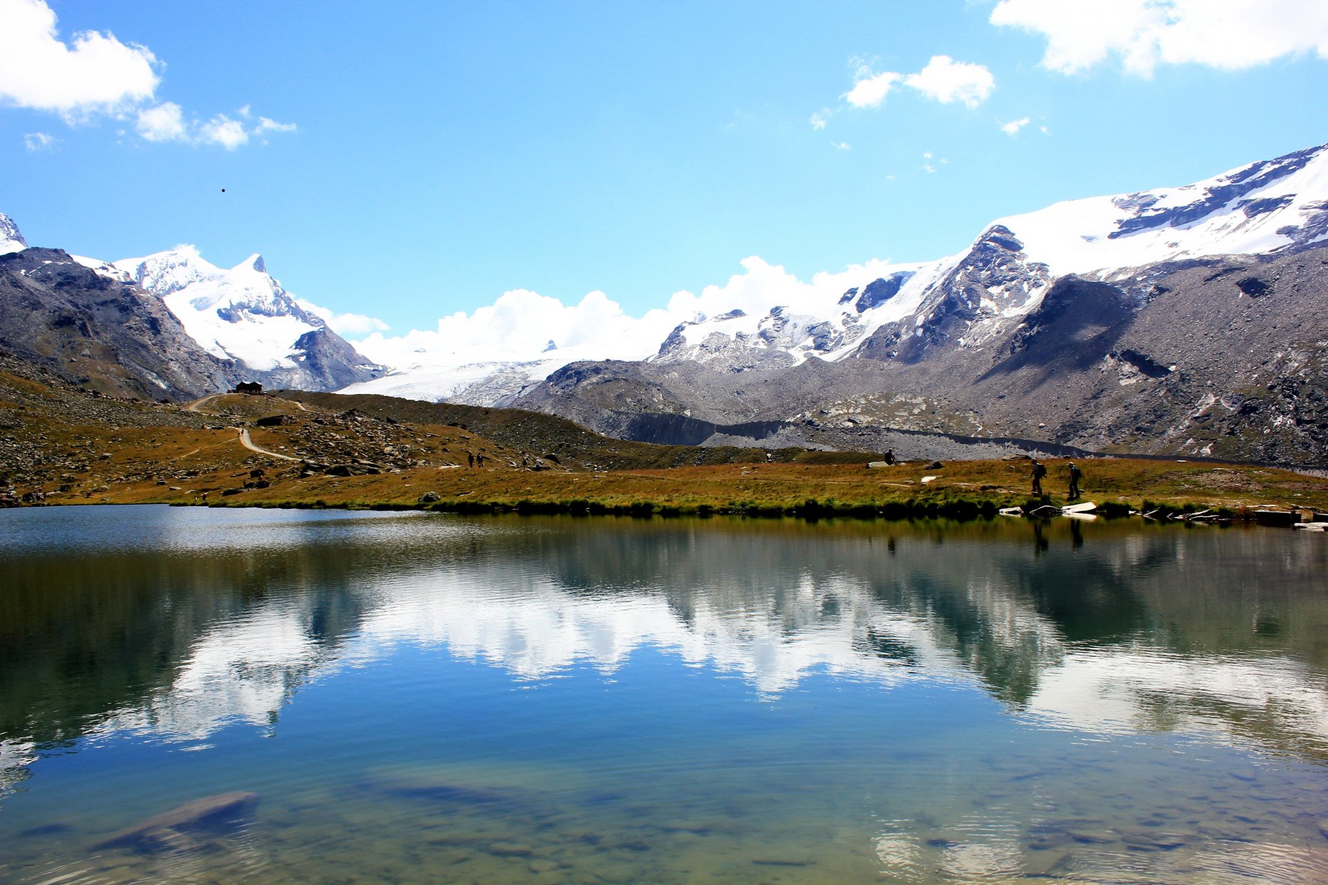 mountain tops snow lake reflection road people sky cloud