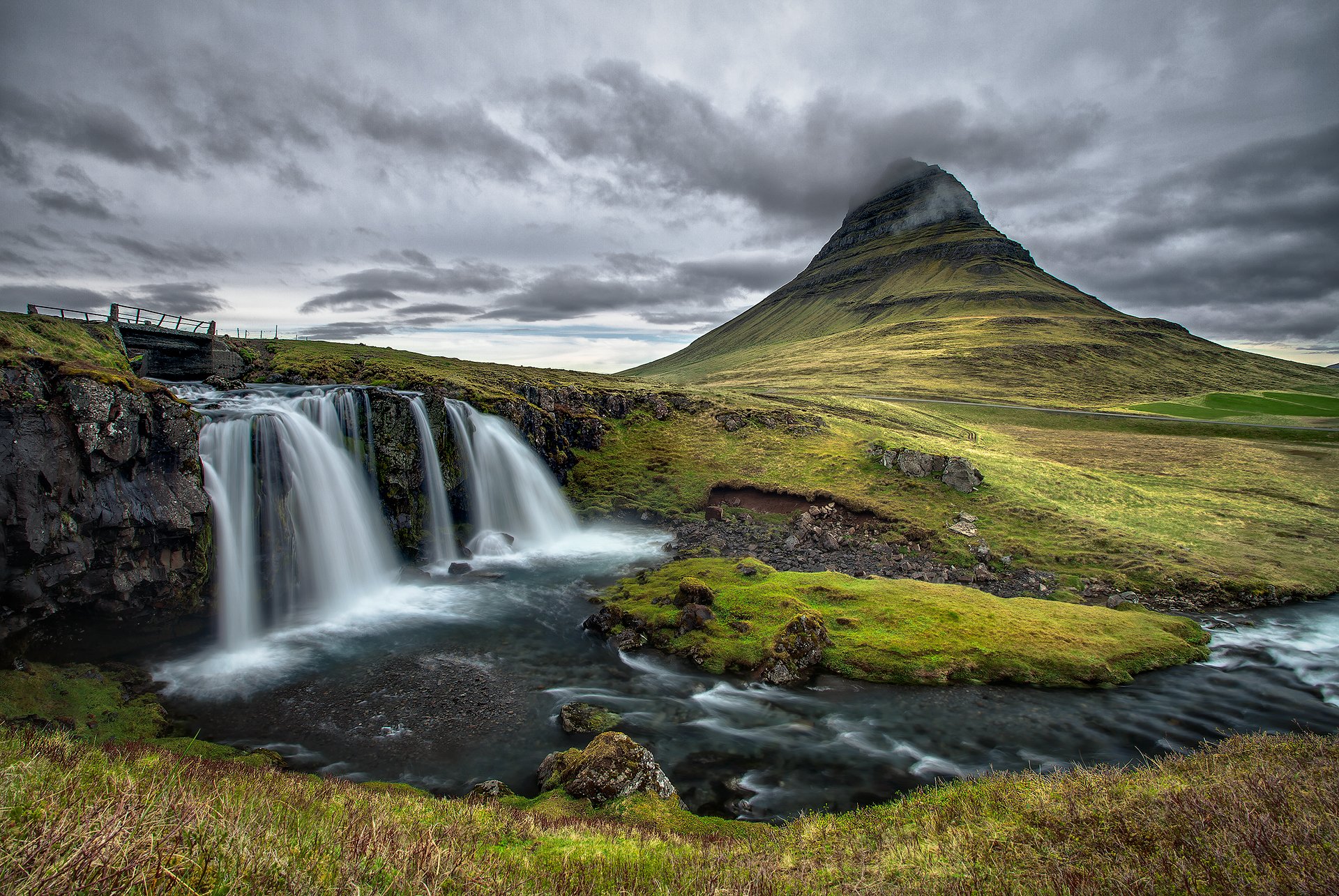 kirkjufell islandia niebo chmury góra rzeka most wodospad skały