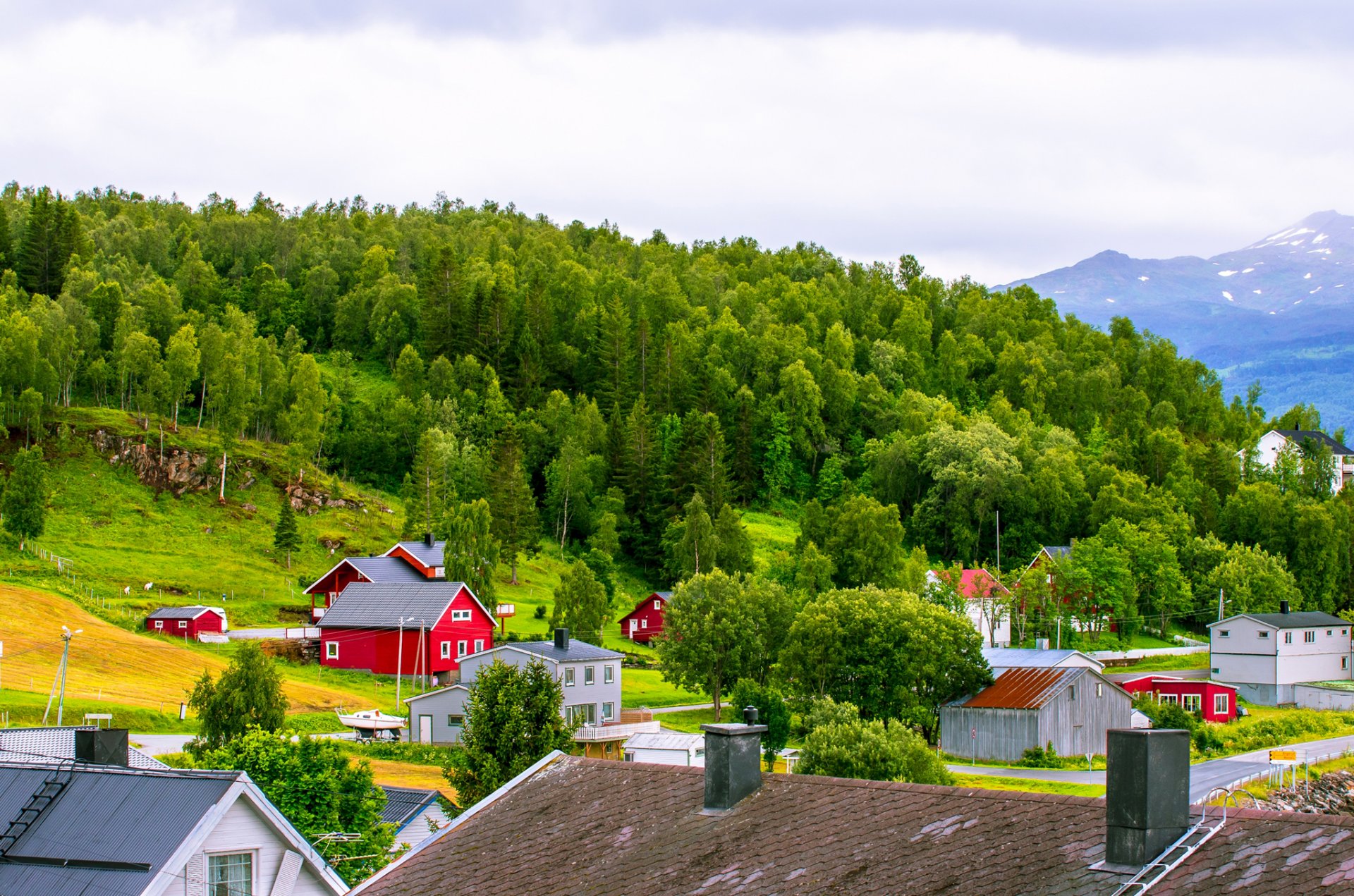 noruega montañas casas techo cielo nubes árboles hierba pendiente