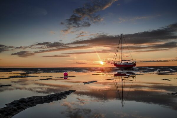 Reefs, a ship on the background of sunset