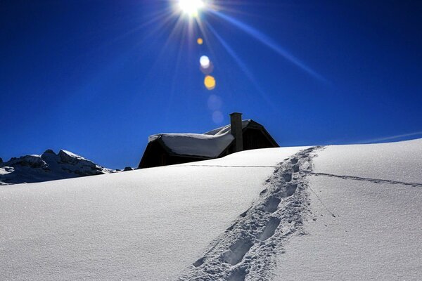 Spuren im Schnee vor dem Hintergrund des blauen Winterhimmels