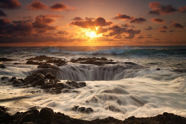 Embudo de cascada en el mar al atardecer