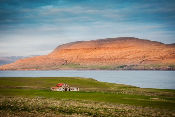 Maison islandaise dans un champ près de la baie