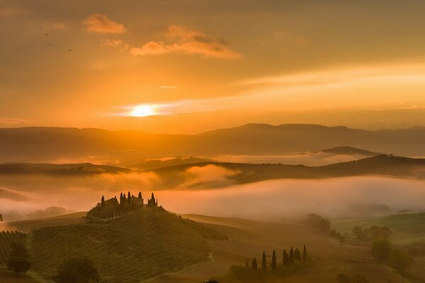 Nebbia che copre la pianura collinare al tramonto