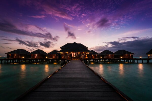 Blick vom Pier auf ein Bungalow-Hotel auf den Malediven
