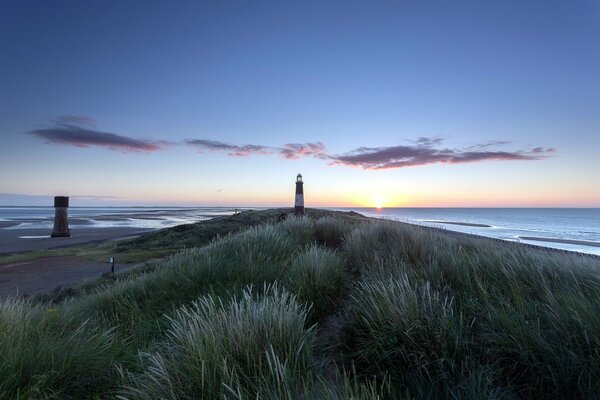 Phare solitaire au coucher du soleil au bord de l eau