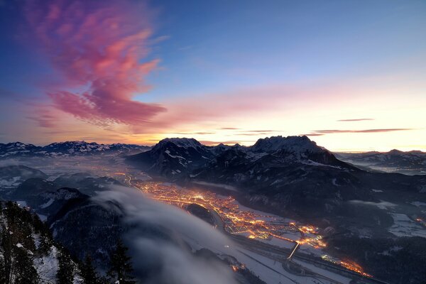 Evening lights of the city in a winter valley among the mountains