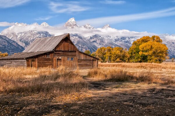 Wooden house in the mountains with beautiful clouds