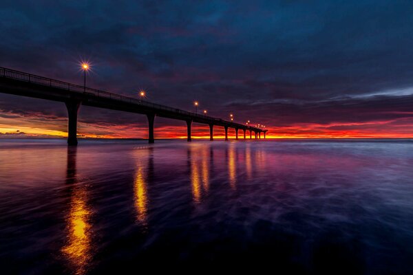 Schöner Sonnenaufgang im Licht der Laternen an einem Pier in Neuseeland