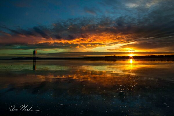 The beautiful rays of the sun at sunset are reflected in the quiet waters of the bay