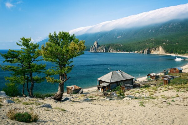 Costa del lago Baikal. Case di legno, alberi, Valle