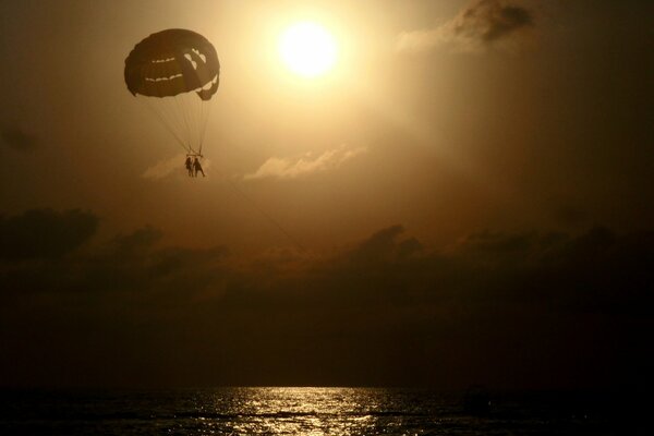 Temps romantique pour un vol en parachute au-dessus de la mer