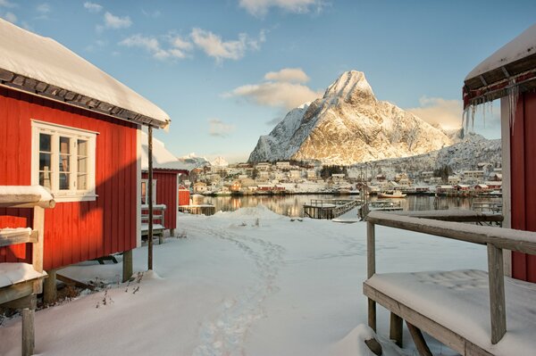 Winter house by the sea on the background of mountains in Norway